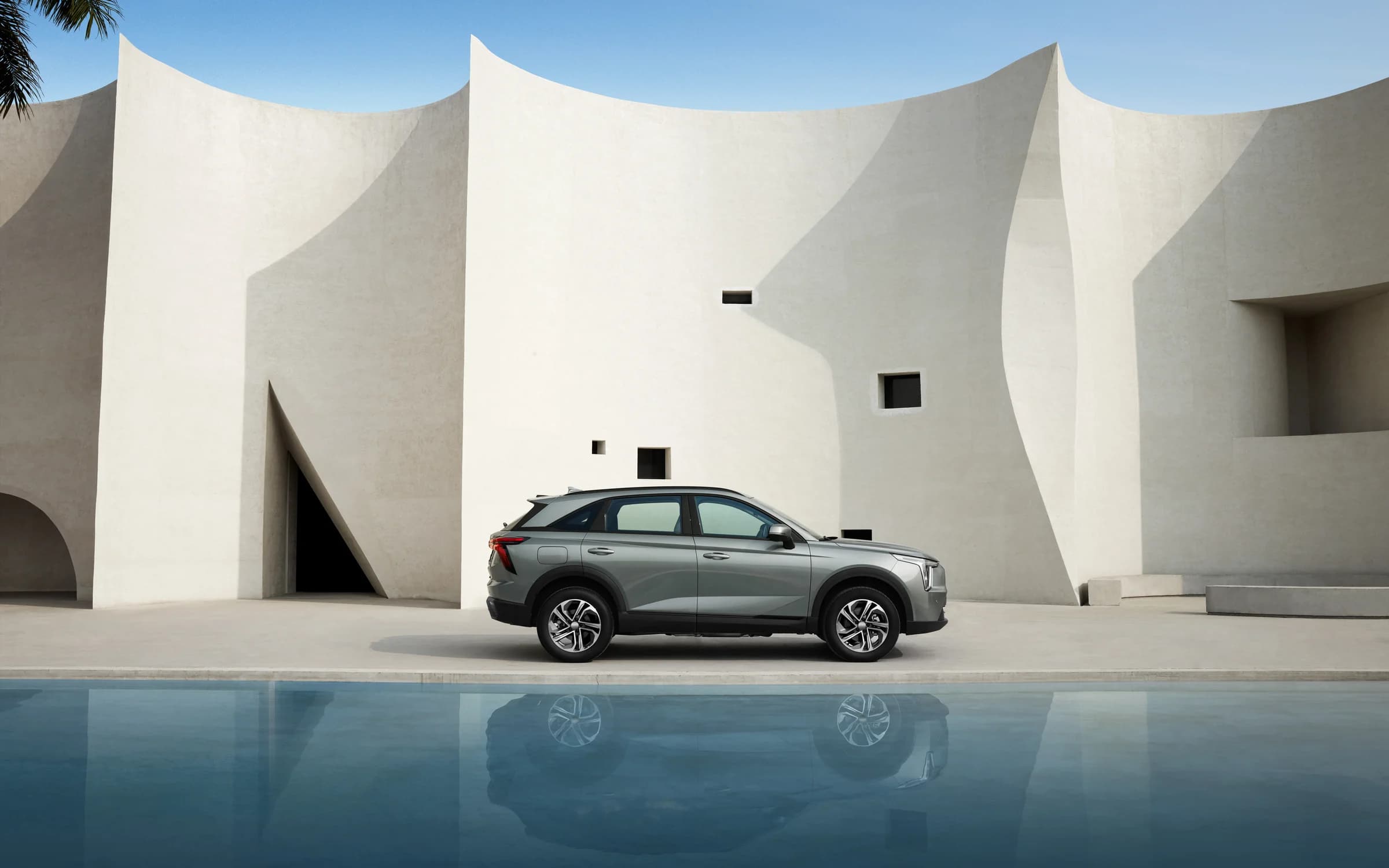 HAVAL Jolion Max EV in profile beside a reflecting pool